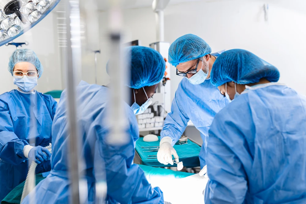 Diverse Team of Professional surgeon, Assistants and Nurses Performing Invasive Surgery on a Patient in the Hospital Operating Room